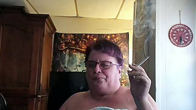 Mature lady, fresh out of the shower, no makeup, eyeglases, smoking a cigarette listening to radio